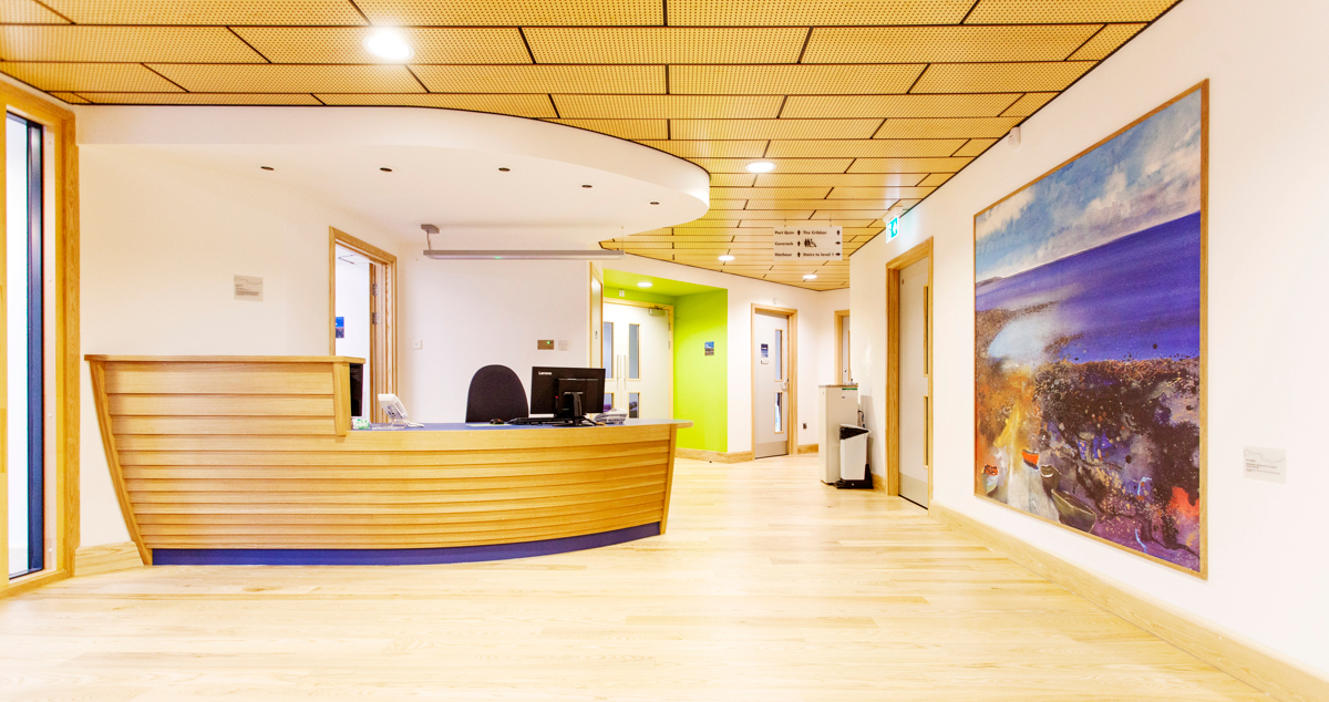 Scott Woyka's reception desk made using boat-building techniques, with base colour selected to tone with Kurt Jackson's painting