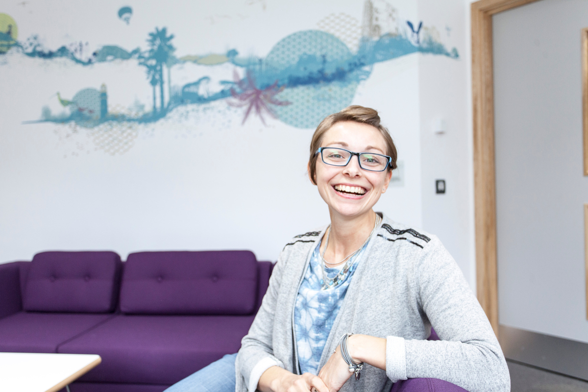 Artist Chelsea Holter pictured with her wall mural. Image courtesy of Mike Newman
