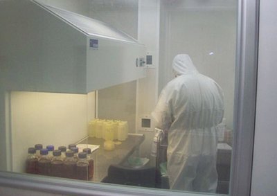 Looking through the corridor window into the new cleanroom facilities showing the testing performed under fume hoods and positive pressure airflow